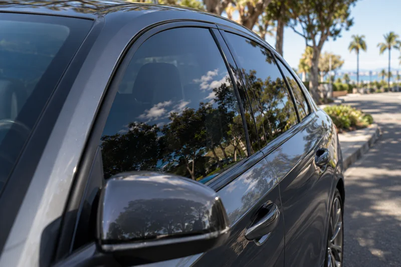 Close-up of tinted side glass and its reflection