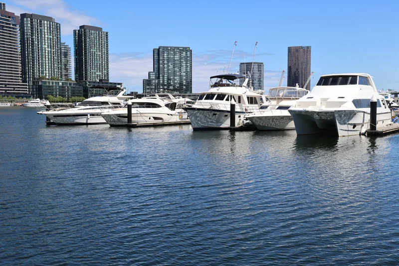 Motor yachts moored in a marina on a sunny day
