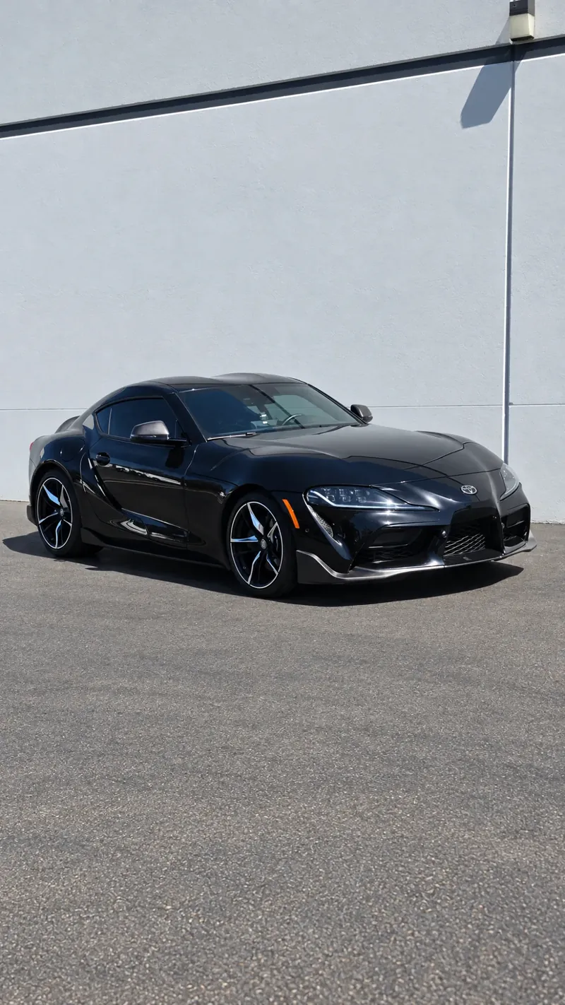 Black Toyota Supra with tinted windows outside the Avanti Window Tint shop in San Diego
