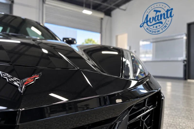 The wrapped edge of clear paint protection film on a black Corvette